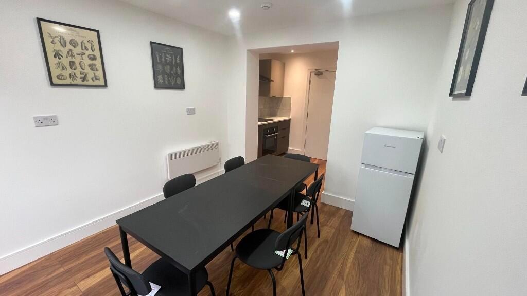 Simple modern kitchen-diner with a long black d...