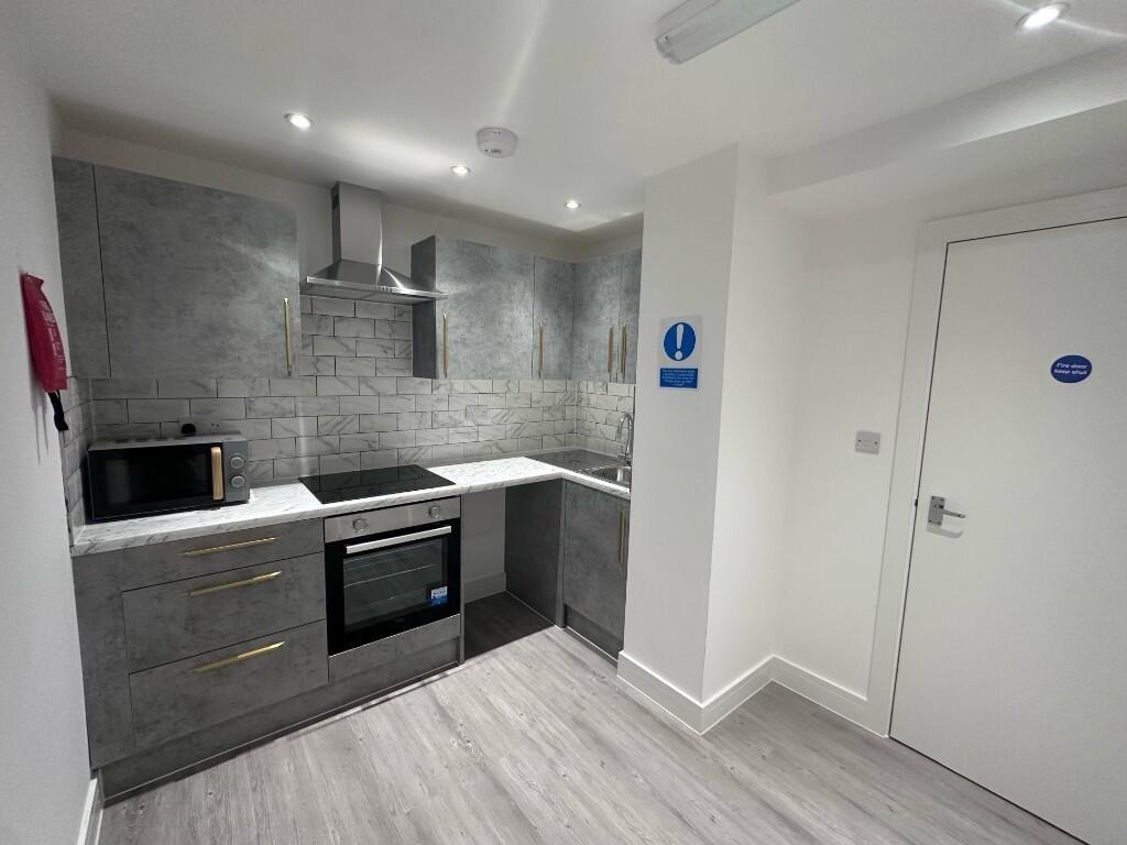 Modern fitted kitchenette with integrated oven,...
