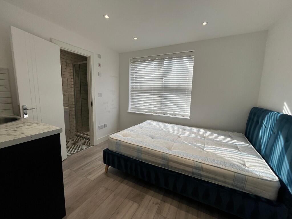 Bright, modern double bedroom with a large wind...