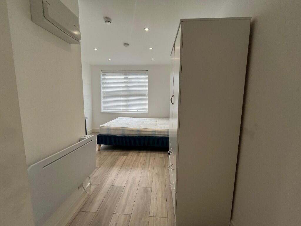 Bright, simply furnished bedroom with a double ...