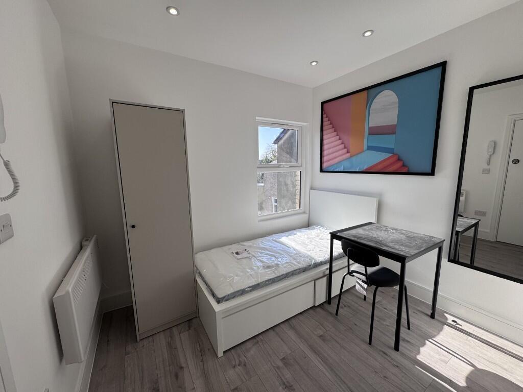 Bright, simply furnished bedroom with a single ...