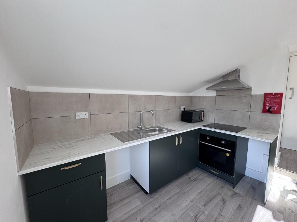 Bright modern kitchenette with grey cabinetry, ...