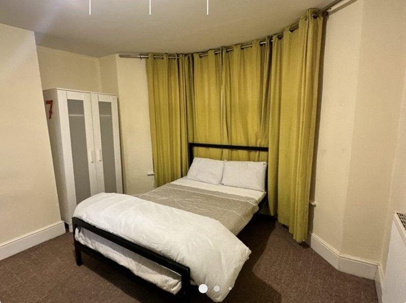 Cozy double bedroom featuring a well-made bed w...
