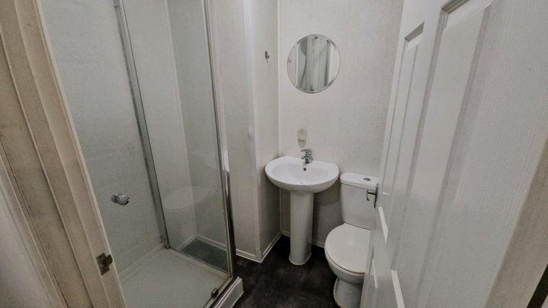 A neat and functional bathroom featuring a walk...