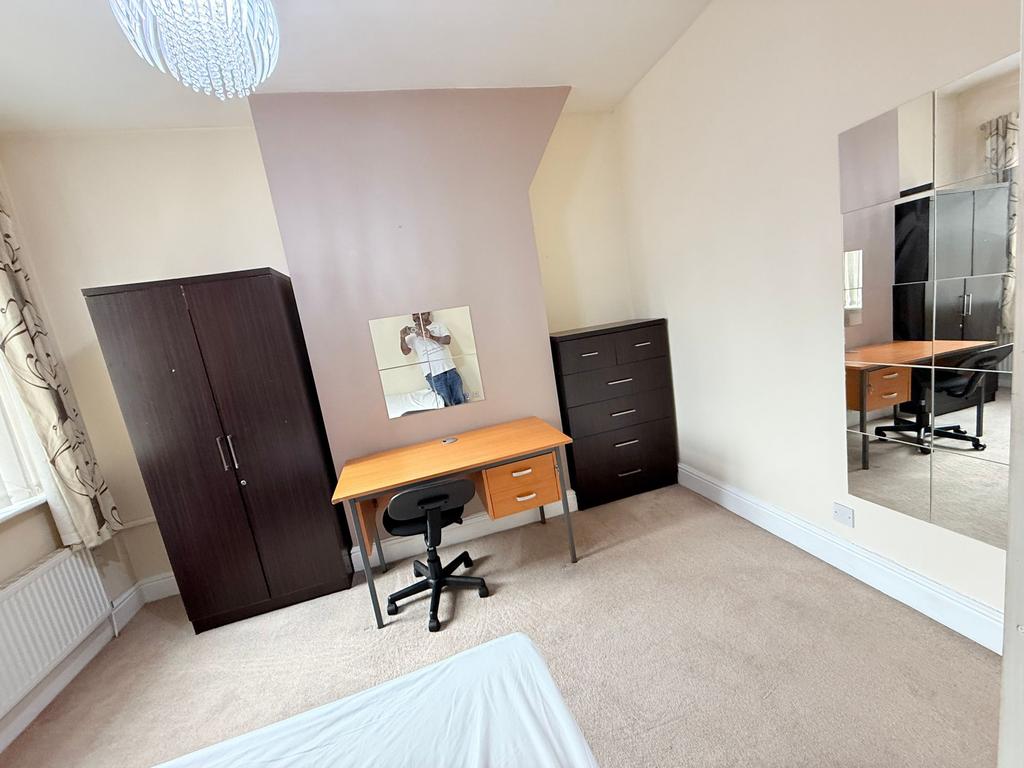 Bright, neutrally decorated bedroom with a stud...