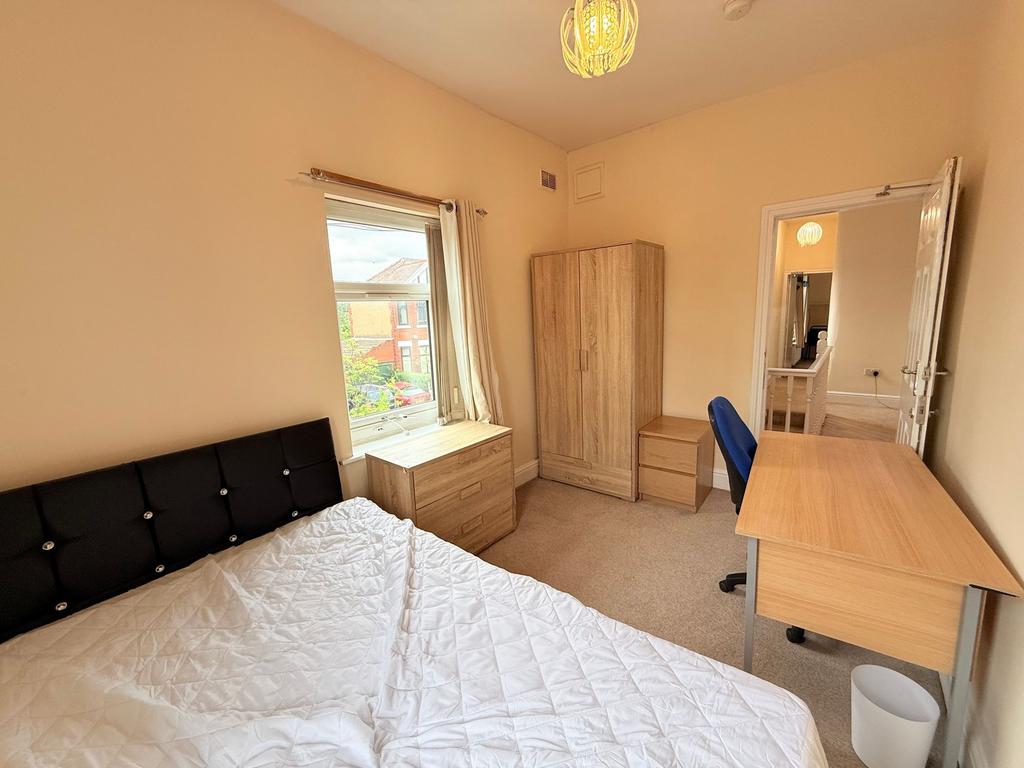Bright, simply furnished bedroom with a comfort...