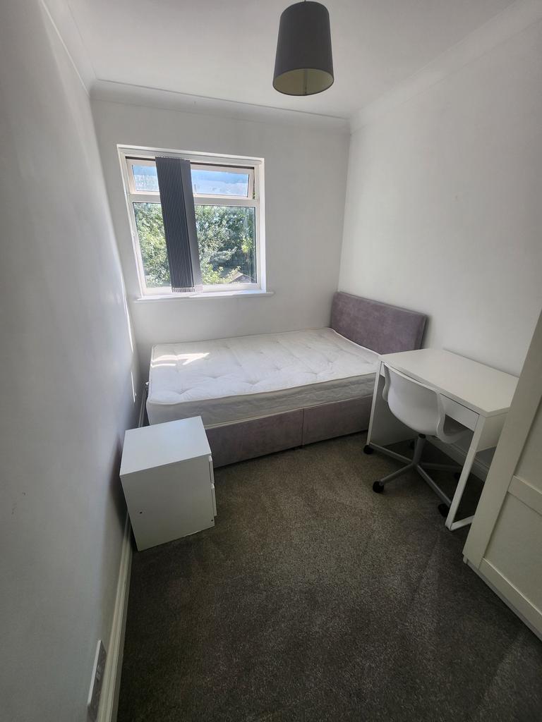 Bright, simply furnished bedroom with a comfort...