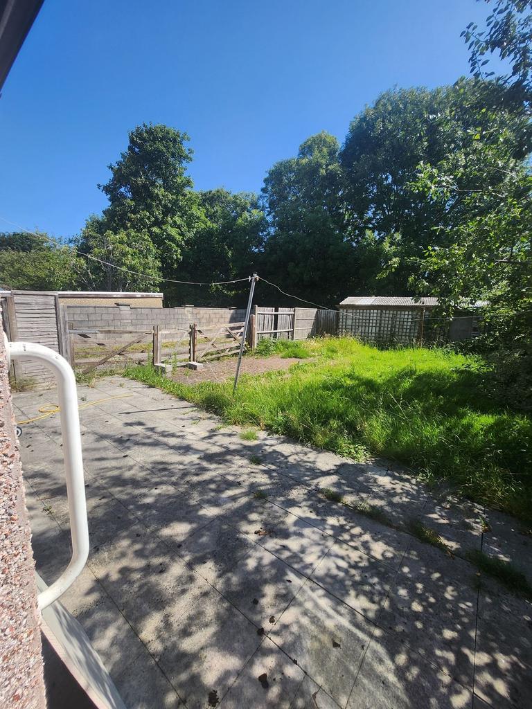 Sunny rear garden with a paved patio area, esta...