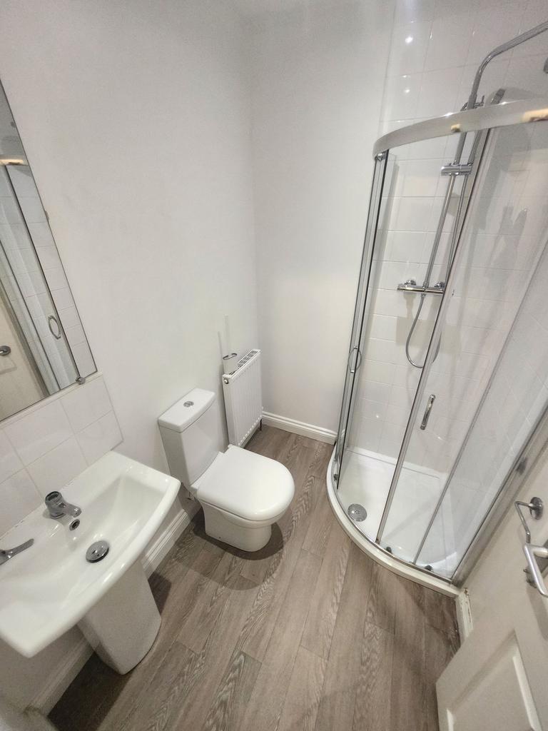 Bright, modern bathroom with a curved glass sho...