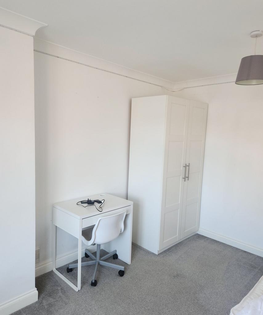 Bright, minimalist single bedroom corner with a...