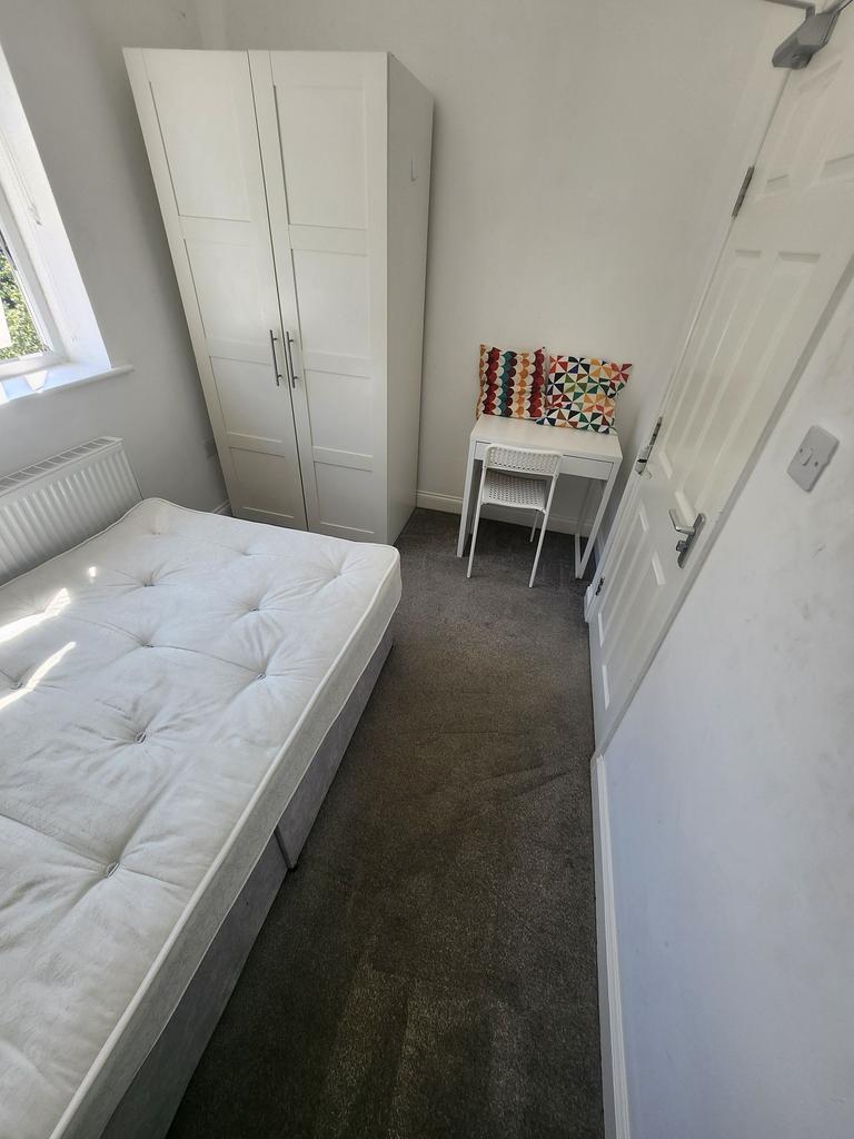 Bright, simply furnished bedroom with a comfort...