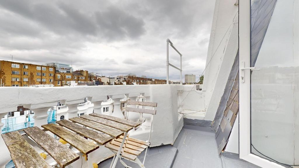 Top-floor balcony with a compact bistro table a...