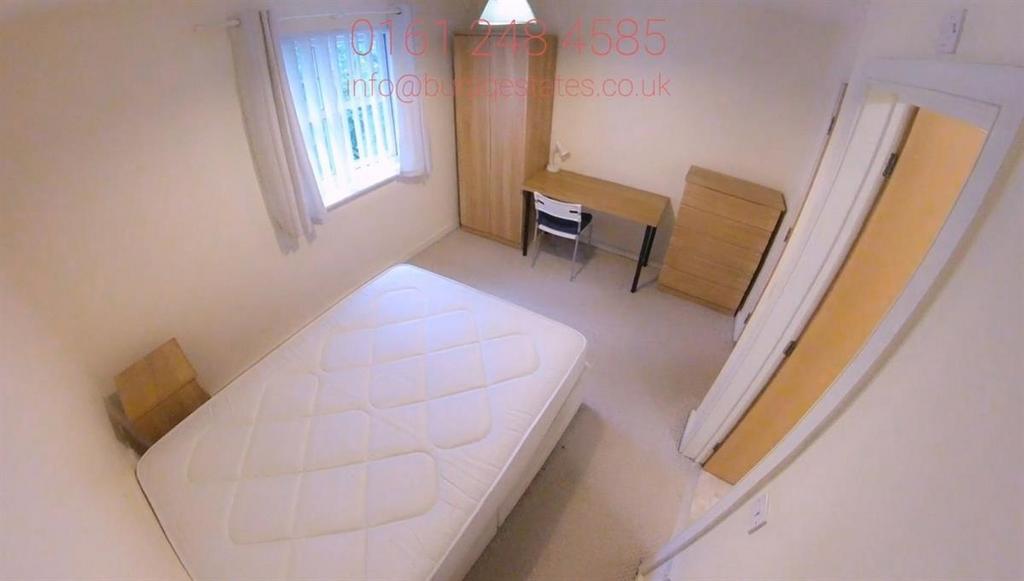 Bright, simply furnished bedroom with a double ...