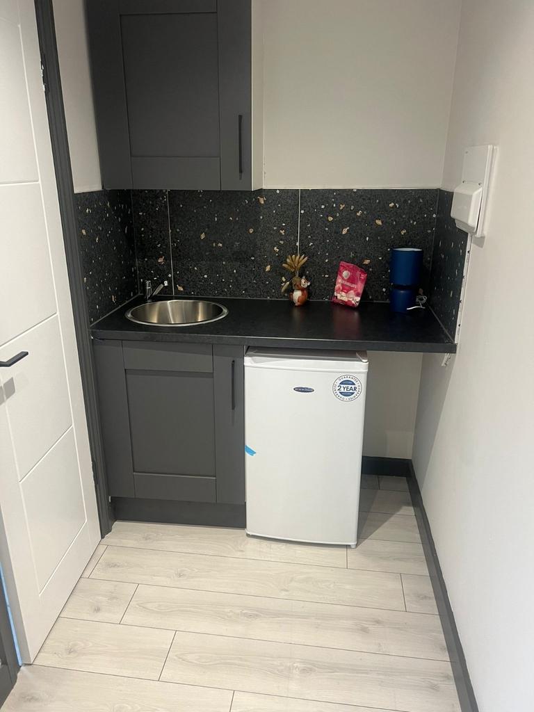 Compact modern kitchenette with a sleek black c...