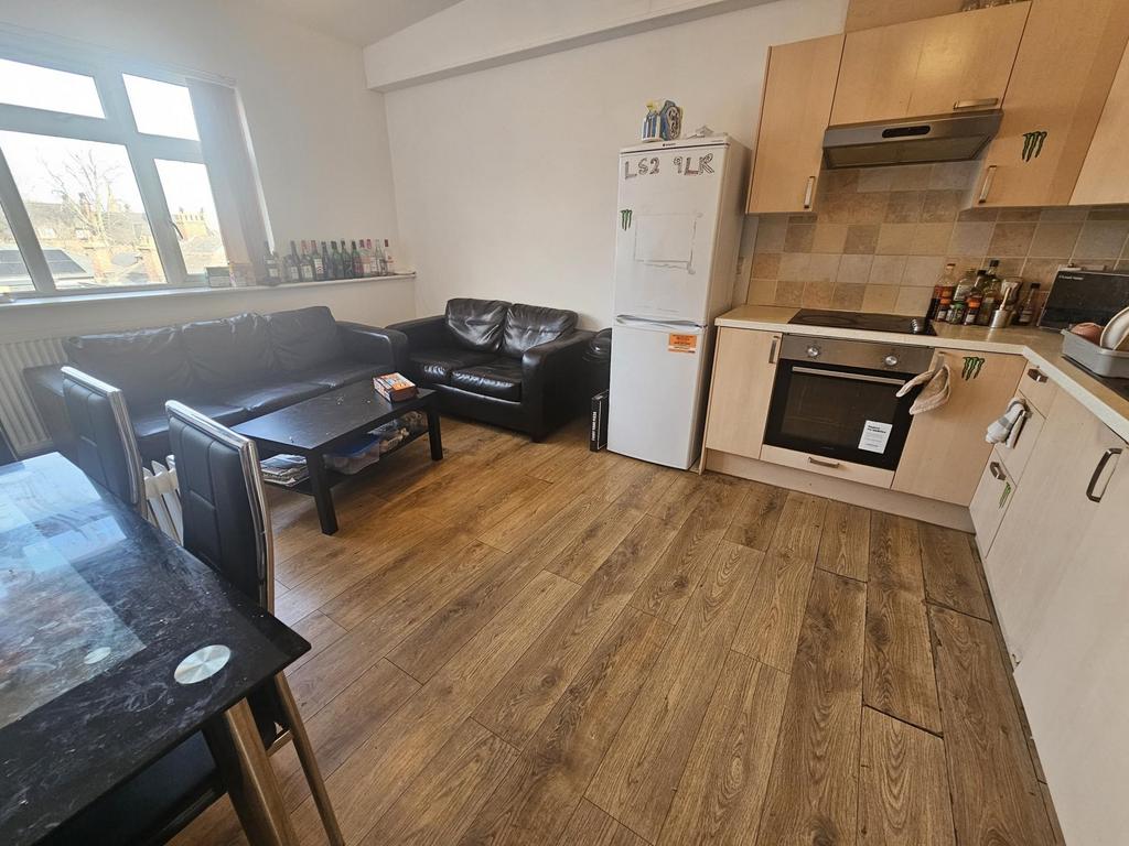 Open-plan kitchen and seating area with wood-ef...