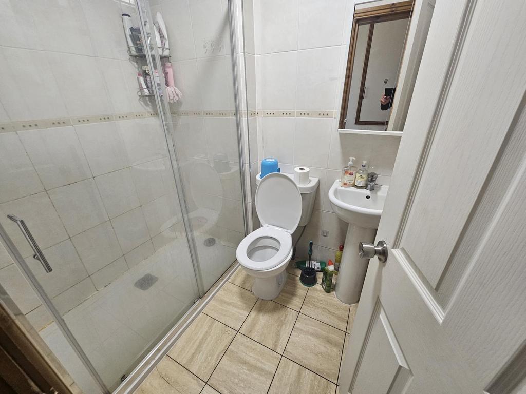 Compact, clean bathroom with a glass-enclosed w...