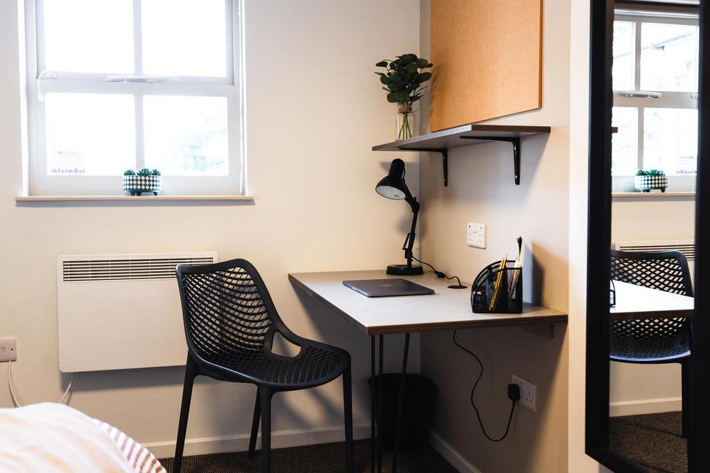 Bright single bedroom with a neat workspace by ...