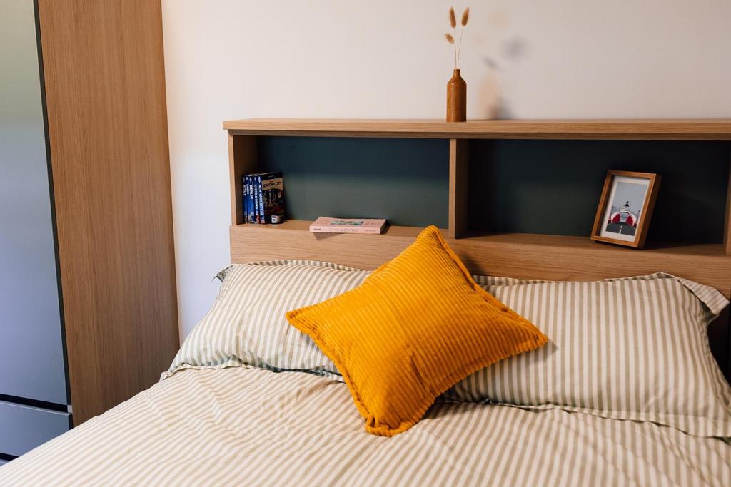 Bright, neatly styled bedroom with a comfortabl...