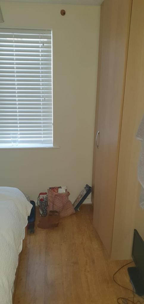 Bright bedroom corner with a large window fitte...