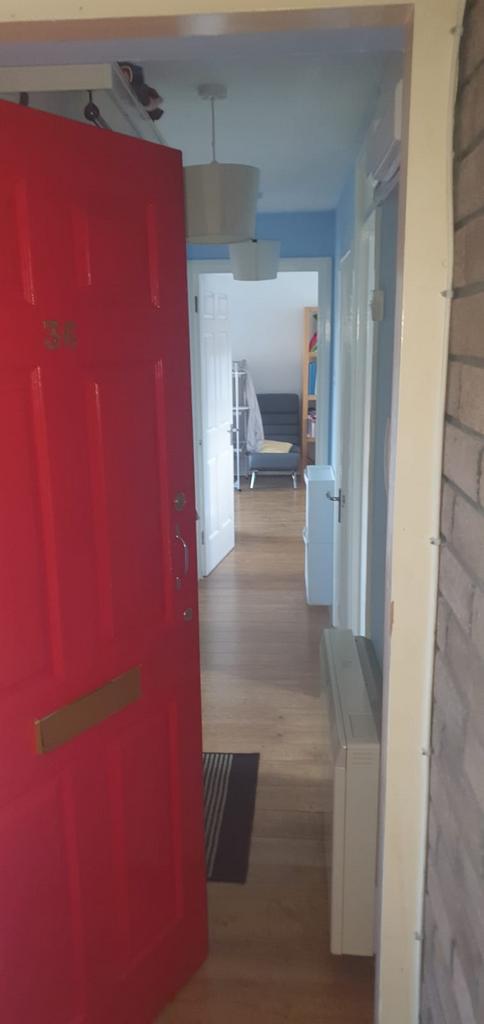 Bright entrance hallway with warm wood-style fl...