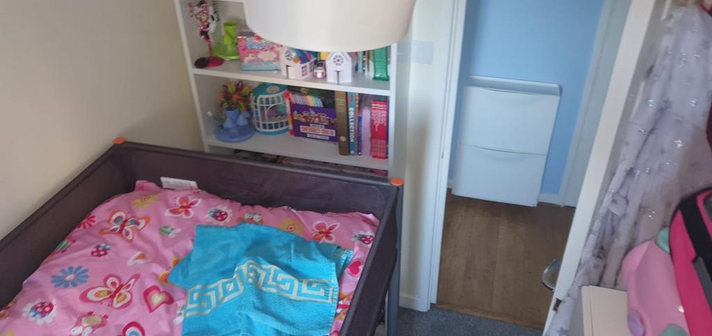 Bright, cosy bedroom with colourful bedding, ha...
