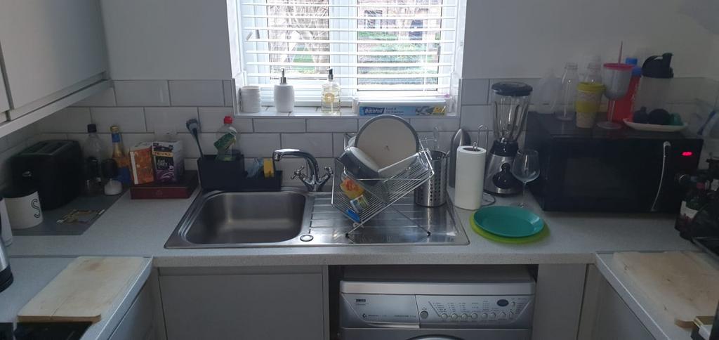 Bright, practical kitchen with a large sink and...