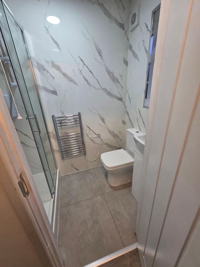 Bright modern bathroom with marble-effect wall ...
