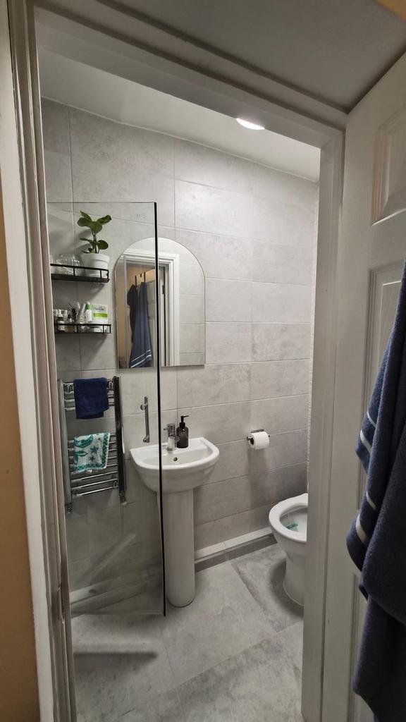 Modern tiled bathroom with a pedestal sink, wal...