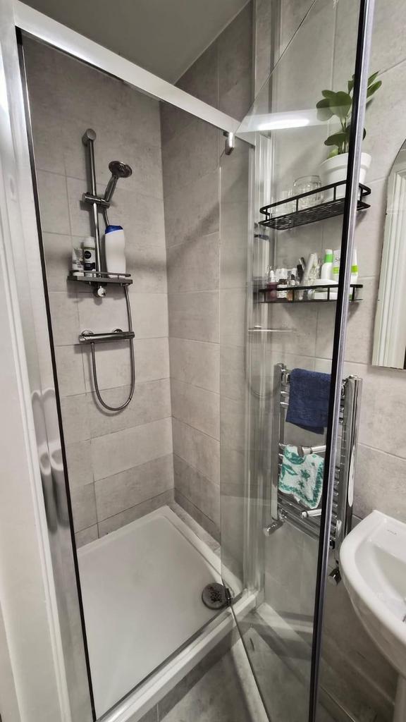 Modern tiled bathroom with a glass shower enclo...