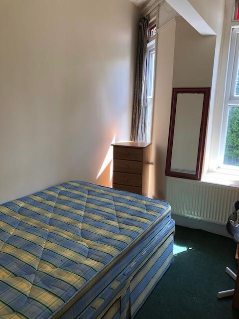 Bright, simply furnished bedroom with a double ...
