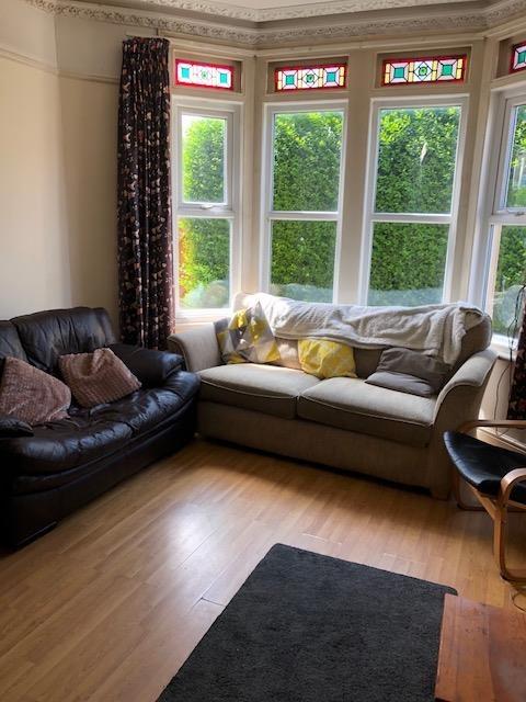 Bright bay-front living room with hardwood floo...