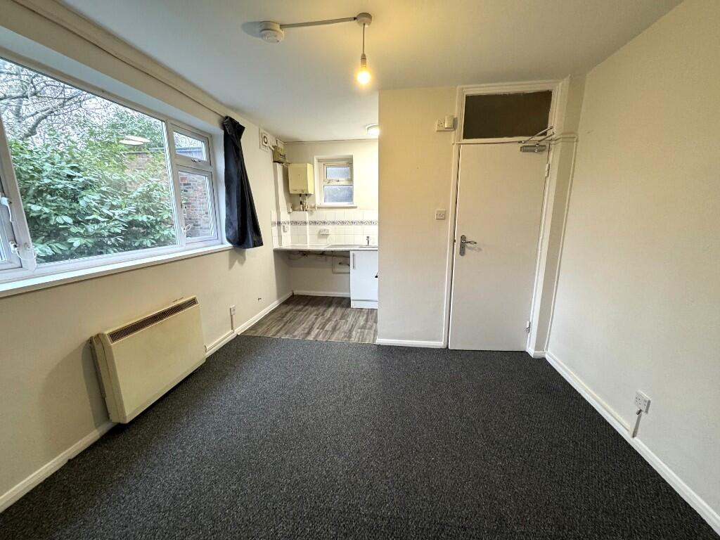 Bright, simply presented bedroom with a large w...