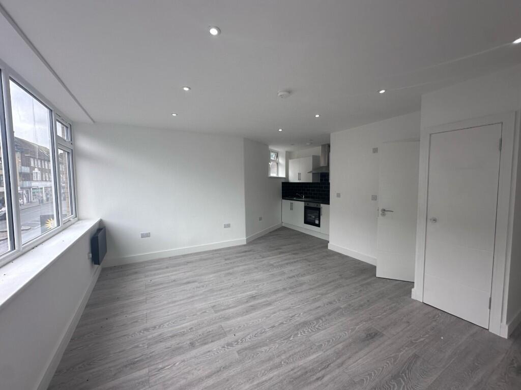 Bright, modern open-plan living area with large...