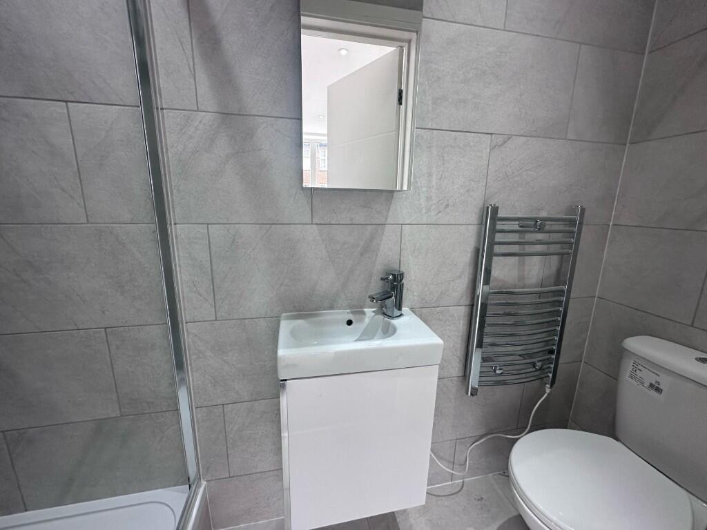 Modern tiled bathroom with a compact vanity uni...