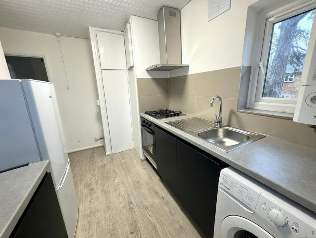 Modern galley kitchen with integrated hob and e...