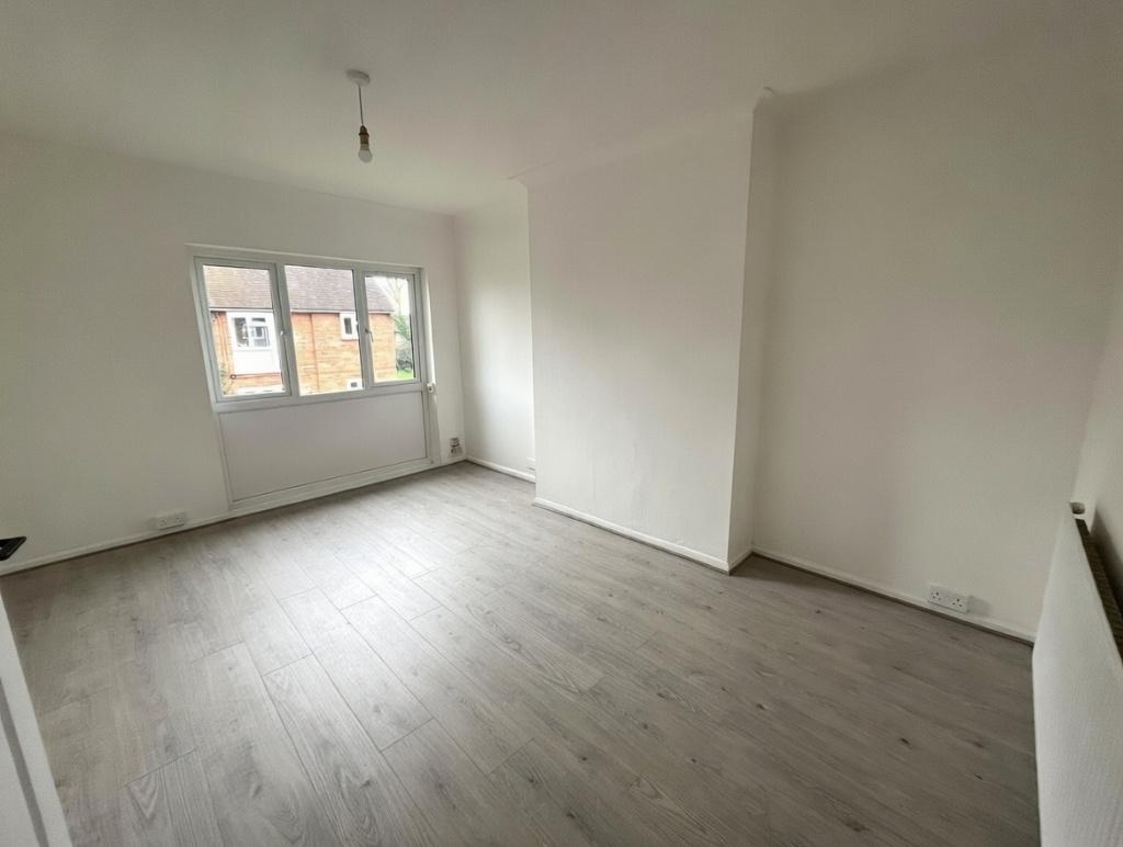 Bright, freshly painted bedroom with large wind...