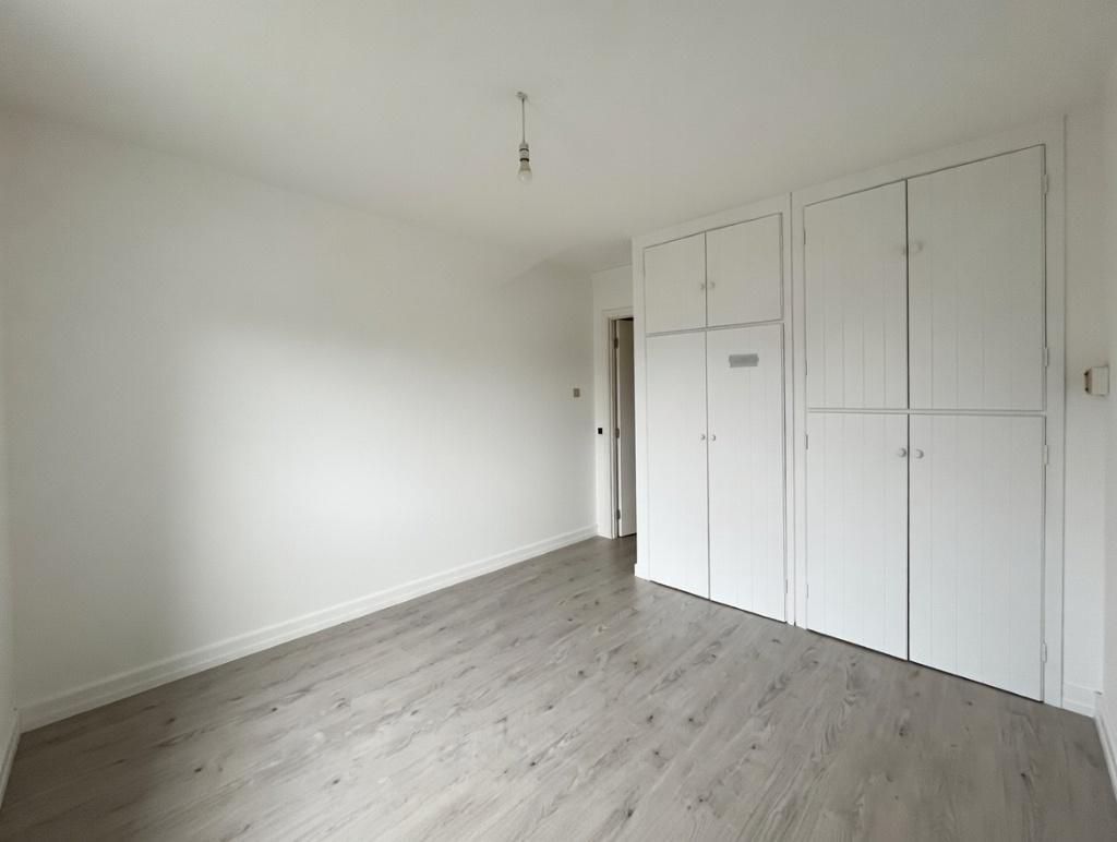 Bright, neutral bedroom with built-in wardrobes...