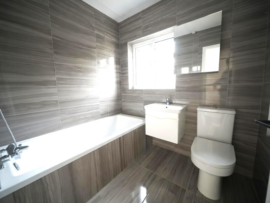 Contemporary tiled bathroom featuring a full-le...