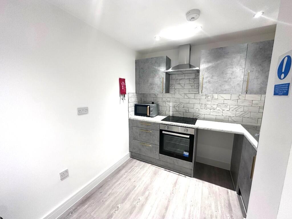 Modern compact kitchen with grey cabinetry, int...