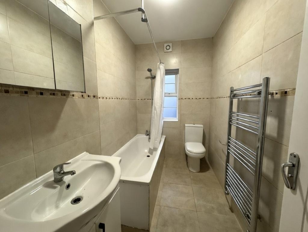 Bright, modern bathroom with tiled walls and fl...