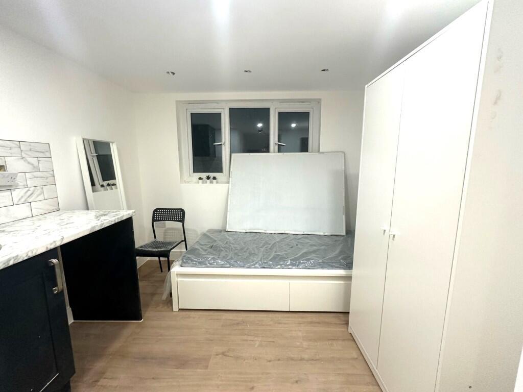 Bright, neatly presented bedroom with a built-i...