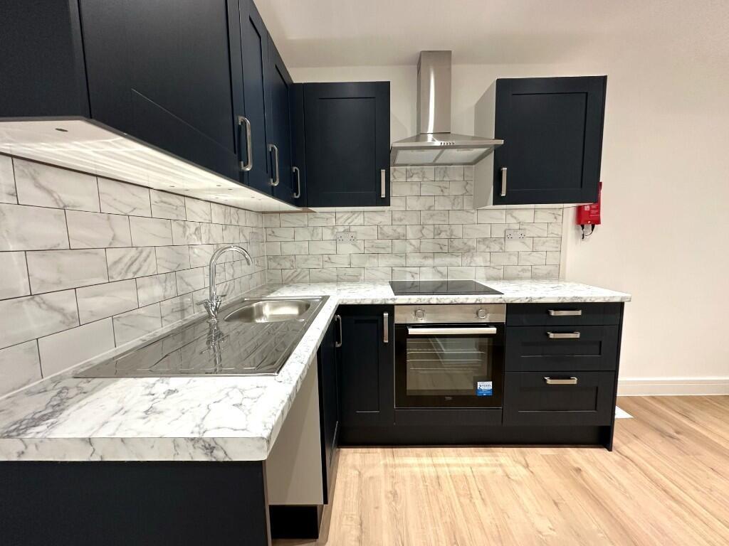Modern fitted kitchen with dark cabinetry, marb...