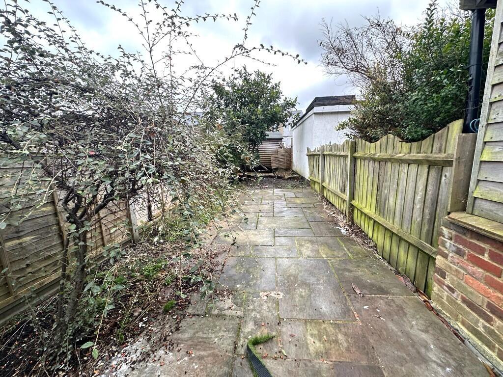 Private paved garden pathway with mature shrubs...