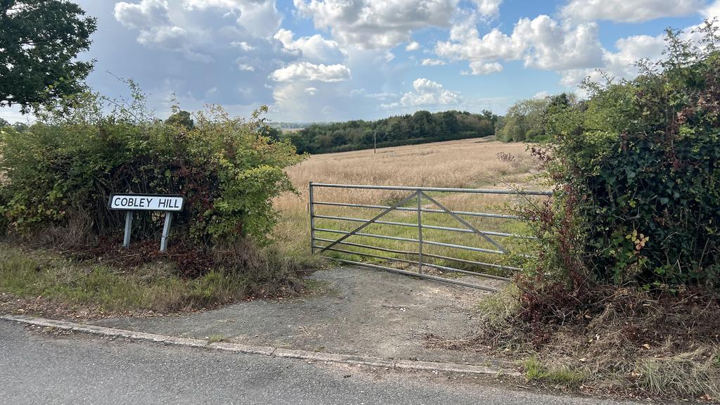 Road frontage and gated entrance to the north.