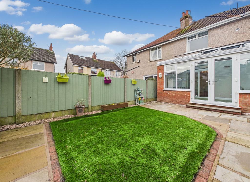 A private, low-maintenance garden with paved...