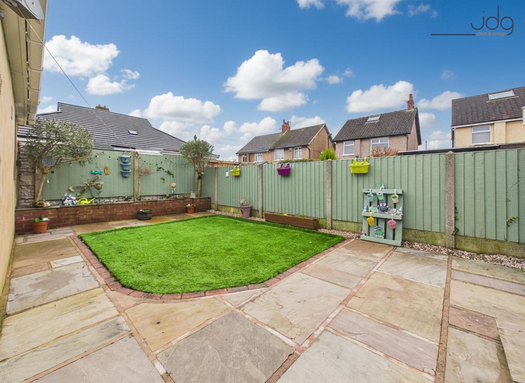 A private, low-maintenance garden with paved...
