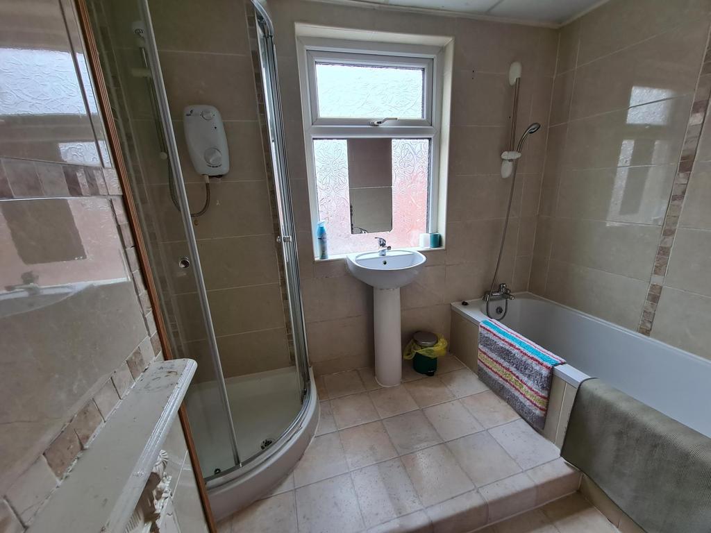Bright, tiled bathroom with a separate shower c...