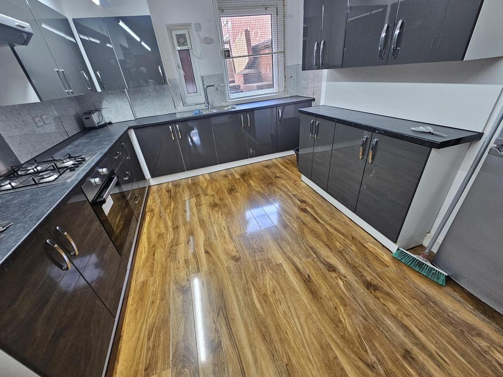 Modern fitted kitchen with glossy dark cabinets...