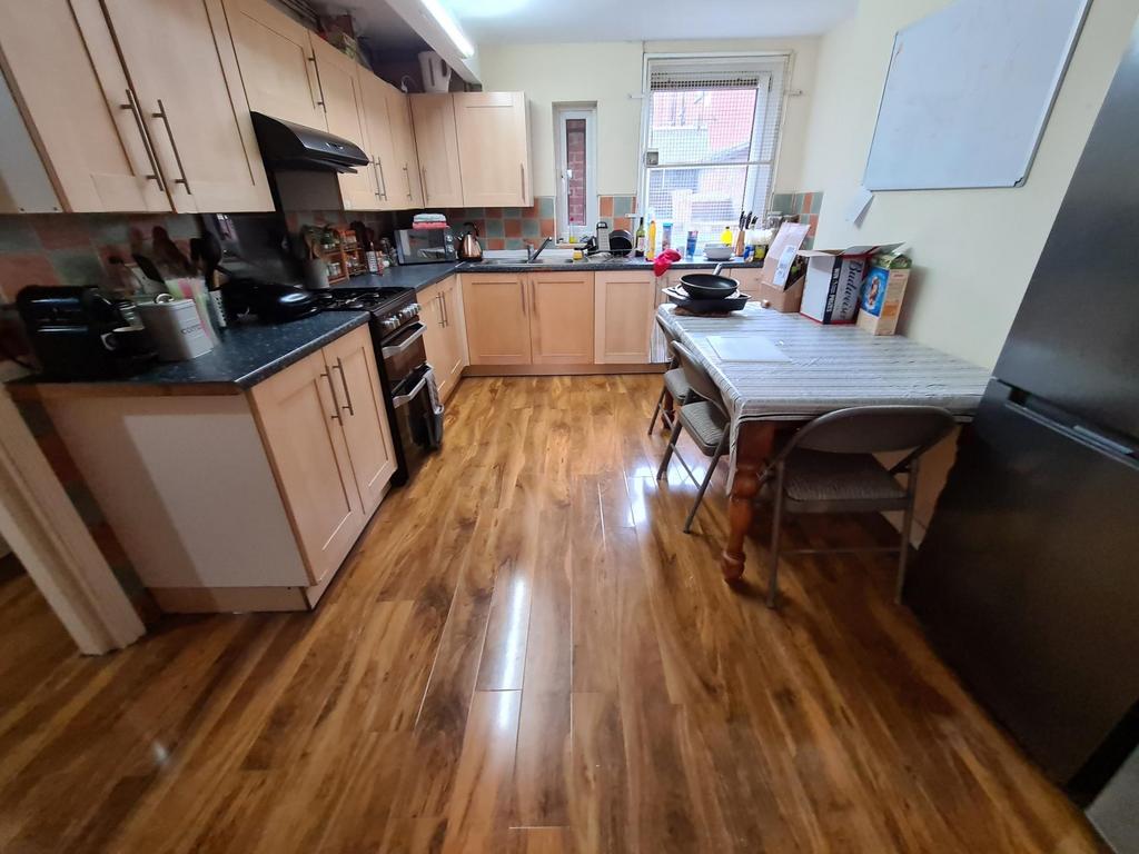 Bright fitted kitchen with light wood cabinets,...