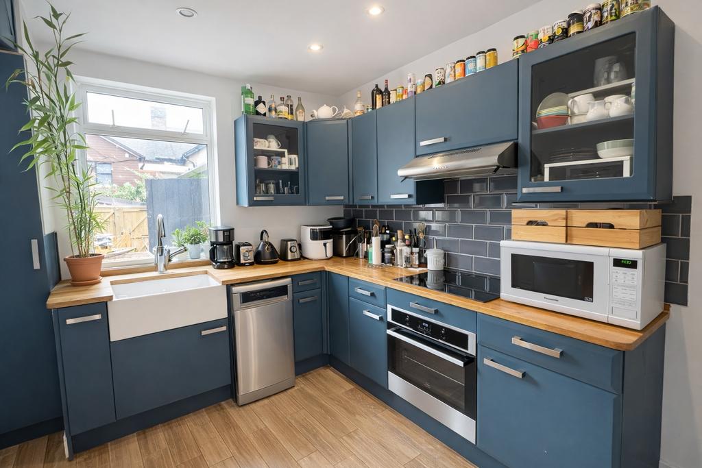 Contemporary blue kitchen with wooden counterto...
